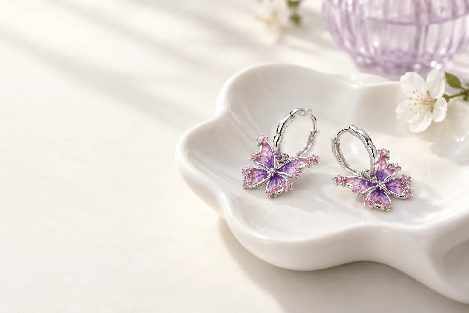 Silver butterfly earrings on white porcelain